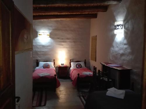a small room with two beds in a room at Sendero De Las Cabras in Purmamarca