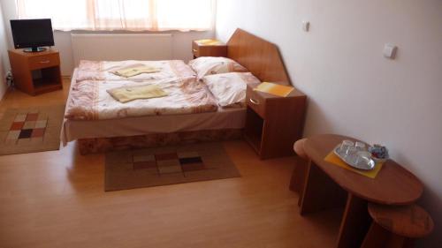 a small bedroom with a bed and two tables at Hotel Štadión in Košice