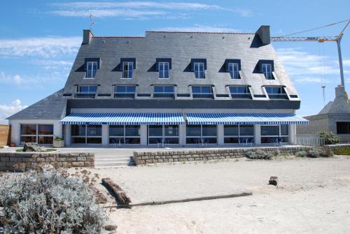 un gran edificio con techo en la playa en Le Sterenn, en Saint-Guénolé
