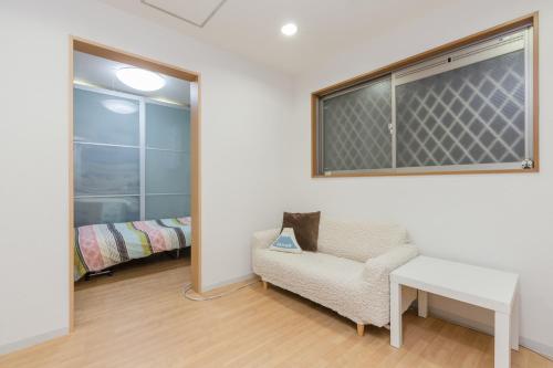 a room with a chair and a table and a window at Awaza House 1 in Osaka