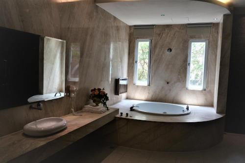 baño grande con bañera y lavamanos en Her Home Spa Motel Xinying, en Xinying