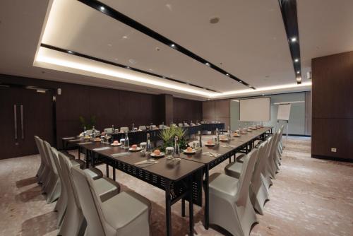 a conference room with a long table and chairs at GRAMM HOTEL by Ambarrukmo Yogyakarta in Yogyakarta