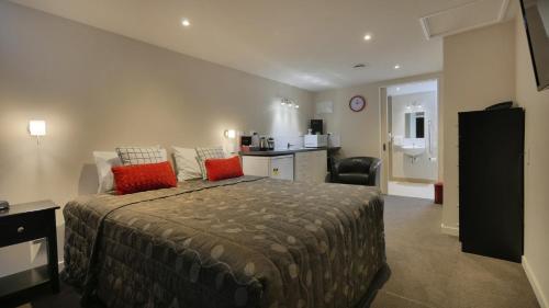 Un dormitorio con una cama grande con almohadas rojas. en Cashel Court Motel, en Christchurch