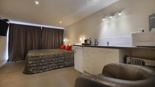 a room with a kitchen and a bed in it at Cashel Court Motel in Christchurch