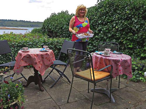 a woman standing next to two tables and a dog at Casa Mundo Bed & Breakfast in Vejle