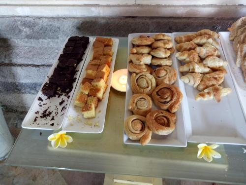a table topped with trays of different types of pastries at The Payogan Villa Resort and Spa in Ubud