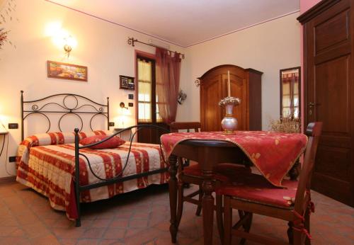 a bedroom with a bed with a table and a chair at B&B Cascina Bellavista in Tigliole