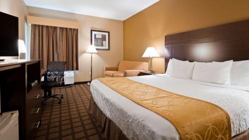 a hotel room with a large bed and a chair at Best Western Plaza Hotel Saugatuck in Saugatuck