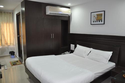 a bedroom with a large white bed and a air conditioner at Hotel Imperial Classic in Hyderabad