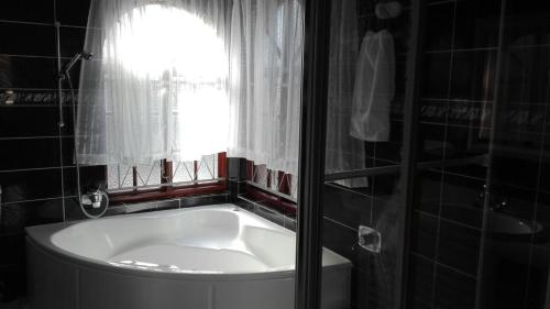 a bath tub in a bathroom with a window at Versailles B and B in Gonubie