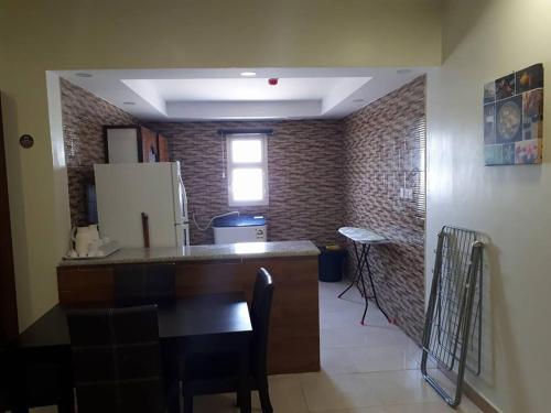 a kitchen with a counter top and a refrigerator at تاج الخليج للشقق المخدومة in Dammam