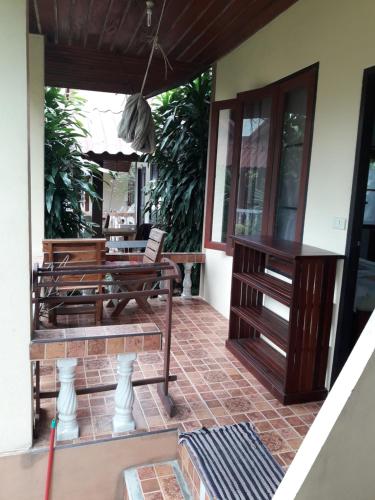 a patio with two benches on a house at Jungle Hut Bungalows & Hotel in Haad Chao Phao