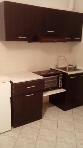 a kitchen with black cabinets and a sink at menidistudios in Menídion