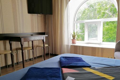 een slaapkamer met een bed, een bureau en een raam bij Apartment on Klochkivska Street in Charkov