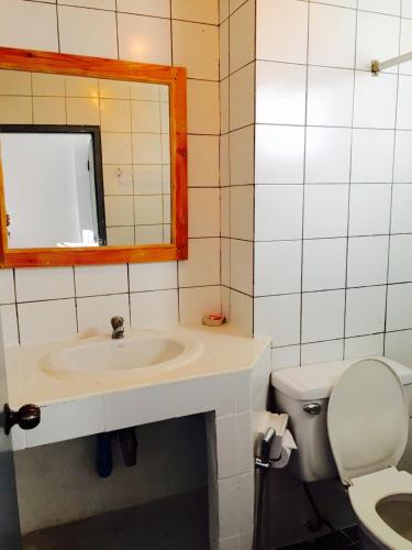 a bathroom with a sink and a mirror and a toilet at Wiang Inn Mansion in Chiang Mai
