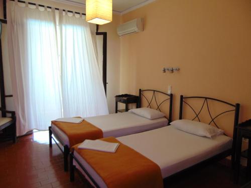 Habitación de hotel con 2 camas y ventana en Annaliza Apartments, en Ýpsos