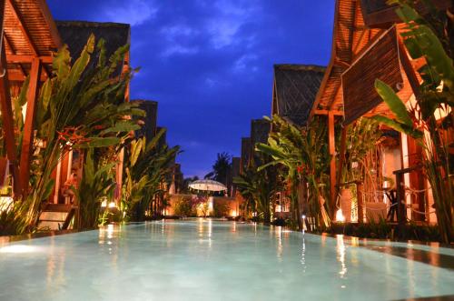 a large swimming pool in a resort at night at Kaleydo Villas in Gili Trawangan