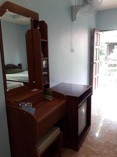a bedroom with a mirror and a tv in a room at Jungle Hut Bungalows & Hotel in Haad Chao Phao