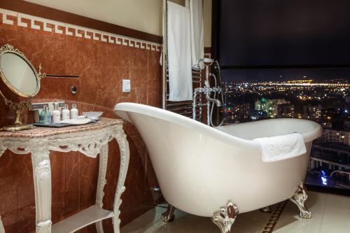 a bath tub in a bathroom with a view of a city at Hotel Marinela Sofia in Sofia