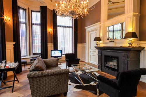 a living room with a fireplace and a chandelier at Post-Plaza Hotel & Grand Café in Leeuwarden
