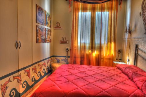 a bedroom with a red bed and a window at Guest House Qui Dormì L'Etrusco in Canino
