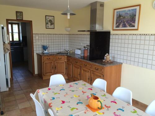 une cuisine avec une table et une cuisine avec une table et des chaises dans l'établissement Gite de la Boheraie, à Chemazé