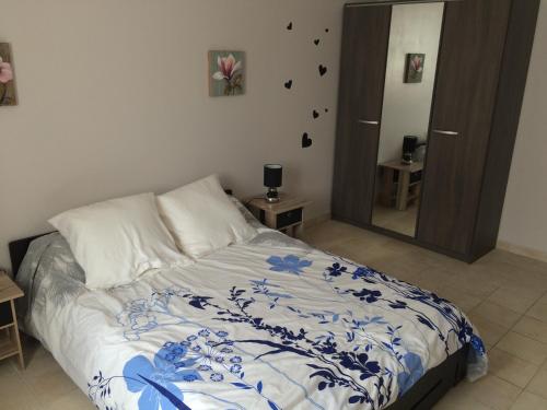 1 dormitorio con 1 cama con edredón azul y blanco en Gite de la Boheraie, en Chemazé