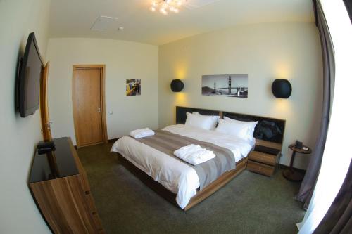 sypialnia z dużym łóżkiem i lustrem w obiekcie Voyage Hotel w mieście Karaganda