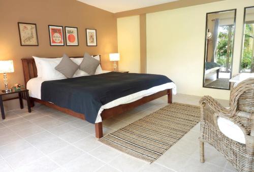 a bedroom with a bed and a chair and a window at Escape-Cabins in Ko Lanta
