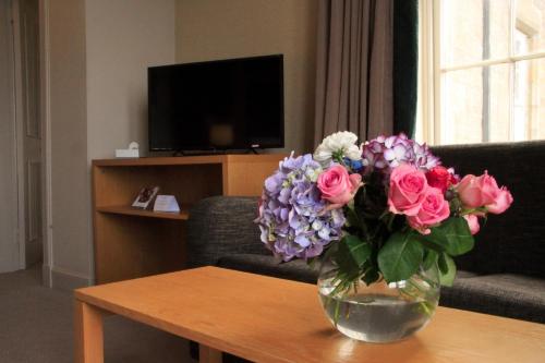 a vase of flowers on a table in a living room at Gairloch Hotel 'A Bespoke Hotel' in Gairloch