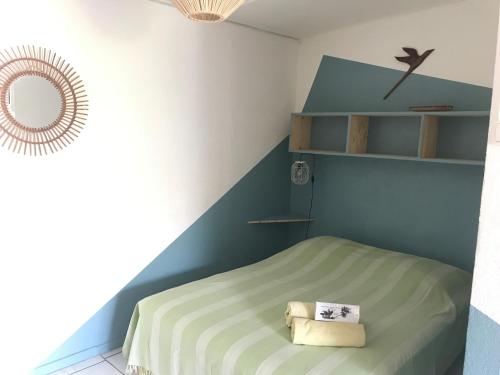 een kleine slaapkamer met een bed en een spiegel bij Les Porcelaines in La Saline les Bains