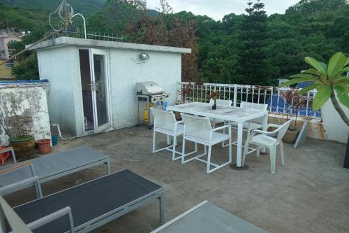 a patio with a table and chairs and a grill at Lantau Lodge in Hong Kong