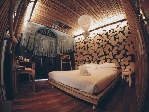 1 dormitorio con cama y pared de troncos en The Happy 8 Retreat @ Old Town Ipoh, en Ipoh