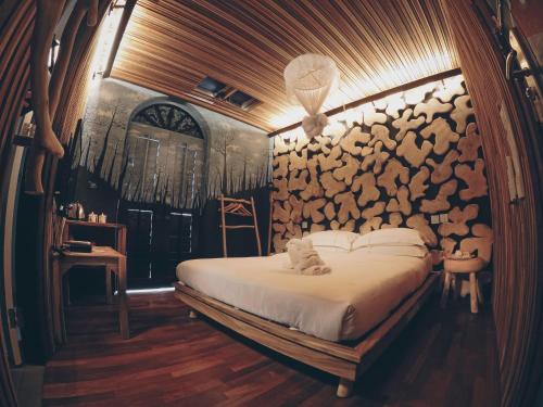 a bedroom with a bed and a wall of logs at The Happy 8 Retreat @ Old Town Ipoh in Ipoh