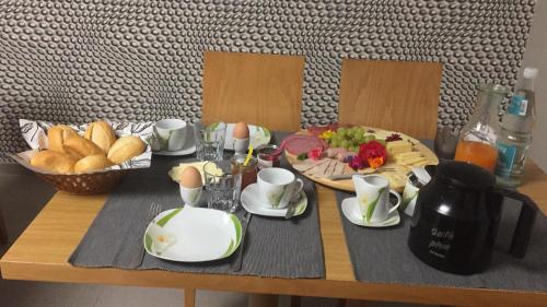 a table with a plate of food and a basket of bread at landpension-dette in Berlingerode