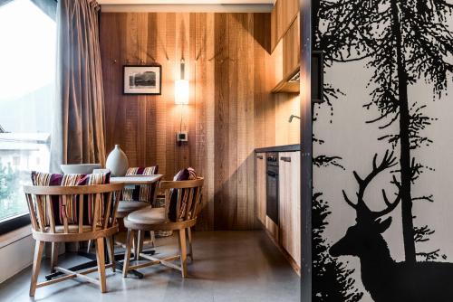 uma sala de jantar com uma mesa e um estêncil de veado na parede em Eden Hotel em Bormio