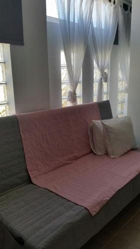 a couch with two pillows in a room with windows at Avenue Study in El Médano