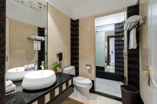 a bathroom with a sink and a toilet and a tub at Nan Yang Royal Hotel in Guangzhou