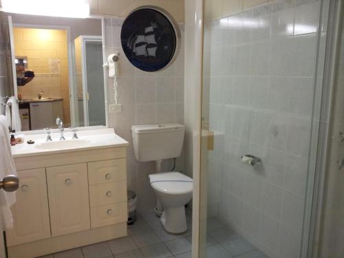 een badkamer met een toilet, een wastafel en een douche bij Admiral Nelson Motor Inn in Nelson Bay