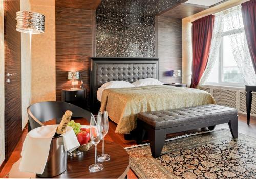 Un dormitorio con una cama y una mesa con un bol de fruta en Beshtau Hotel, en Pyatigorsk