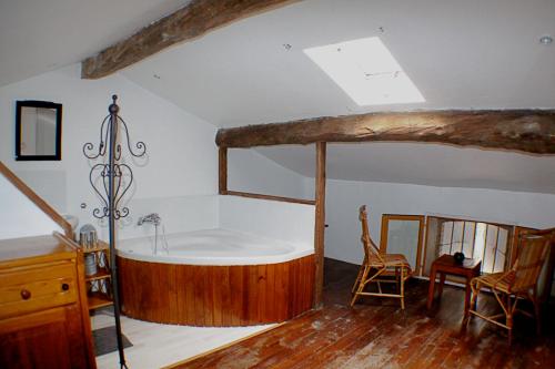a bathroom with a bath tub in a attic at Chambres d'hôtes La Luciole in Tourtrol