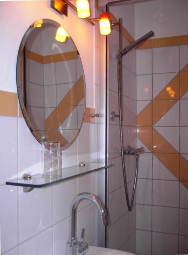 a bathroom with a shower with a mirror and a sink at Weinstube Pension Moselblümchen in Zeltingen-Rachtig