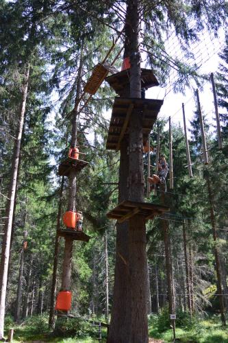 a person in a tree house in a forest at Camping Sur En in Sent