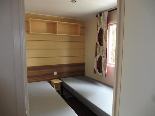 サン・ジャン・ド・モンにあるMobile Home bois dormantのベンチと窓付きの小さな客室です。