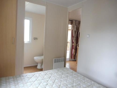 サン・ジャン・ド・モンにあるMobile Home bois dormantのベッドルーム1室(ベッド1台付)、バスルーム(鏡付)