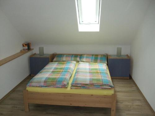 a bed in a small room with a window at Ferienwohnung Bockelt in Stadtlauringen