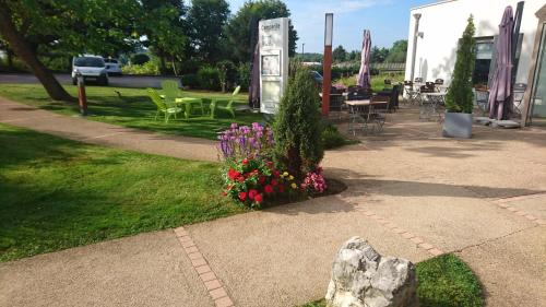 a garden with flowers and tables and chairs at Hotel Campanile Besançon Nord Ecole Valentin in Besançon