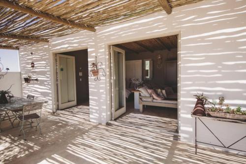 a patio with a table and a couch at Gelukkie in Paternoster