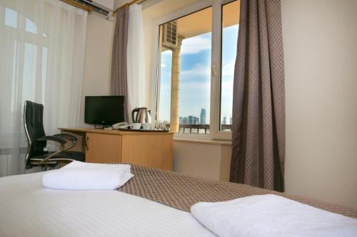 1 dormitorio con cama, escritorio y ventana en Old City Inn Hotel en Bakú
