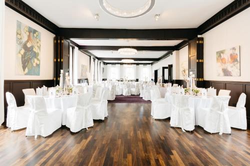 a row of tables and chairs in a banquet hall at Parkhotel FRITZ am Brunnen in Schwelm